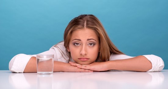 girl-leaning-on-table-with-glass-of-water